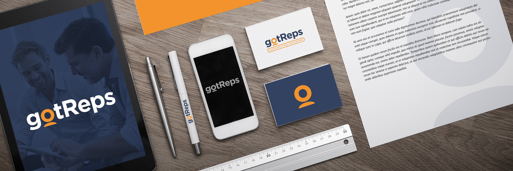 gotReps brand collateral flat-lay: business cards, letterhead, tablet and phone mockups in navy and orange